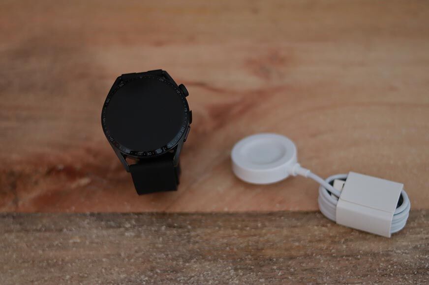 Man sieht die Huawei Watch GT 3 gemeinsam mit ihrem Ladekabel.